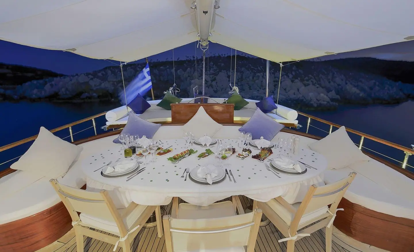 Ecce Navigo yacht dining setup on deck at sunset with table settings