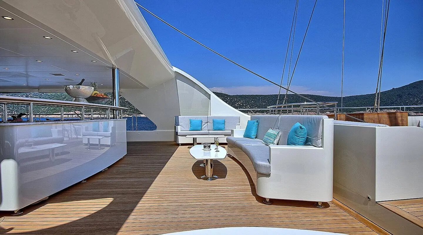 Meira yacht deck seating area with white cushioned benches and circular table