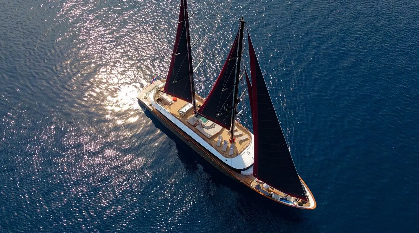 Anetta yacht with twin masts sailing on blue sea from above