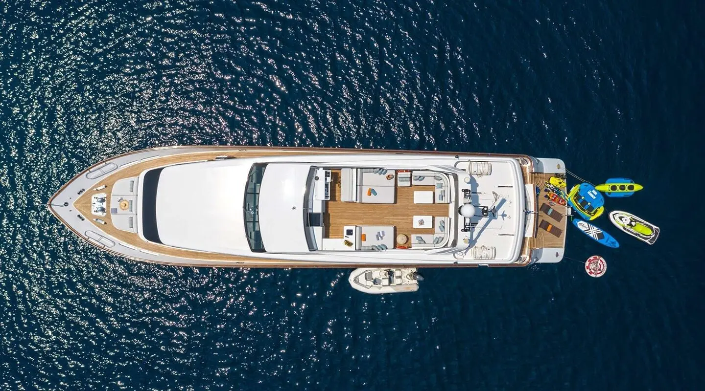Top-down view of a white luxury yacht Grace anchored in dark blue water with a spacious deck.