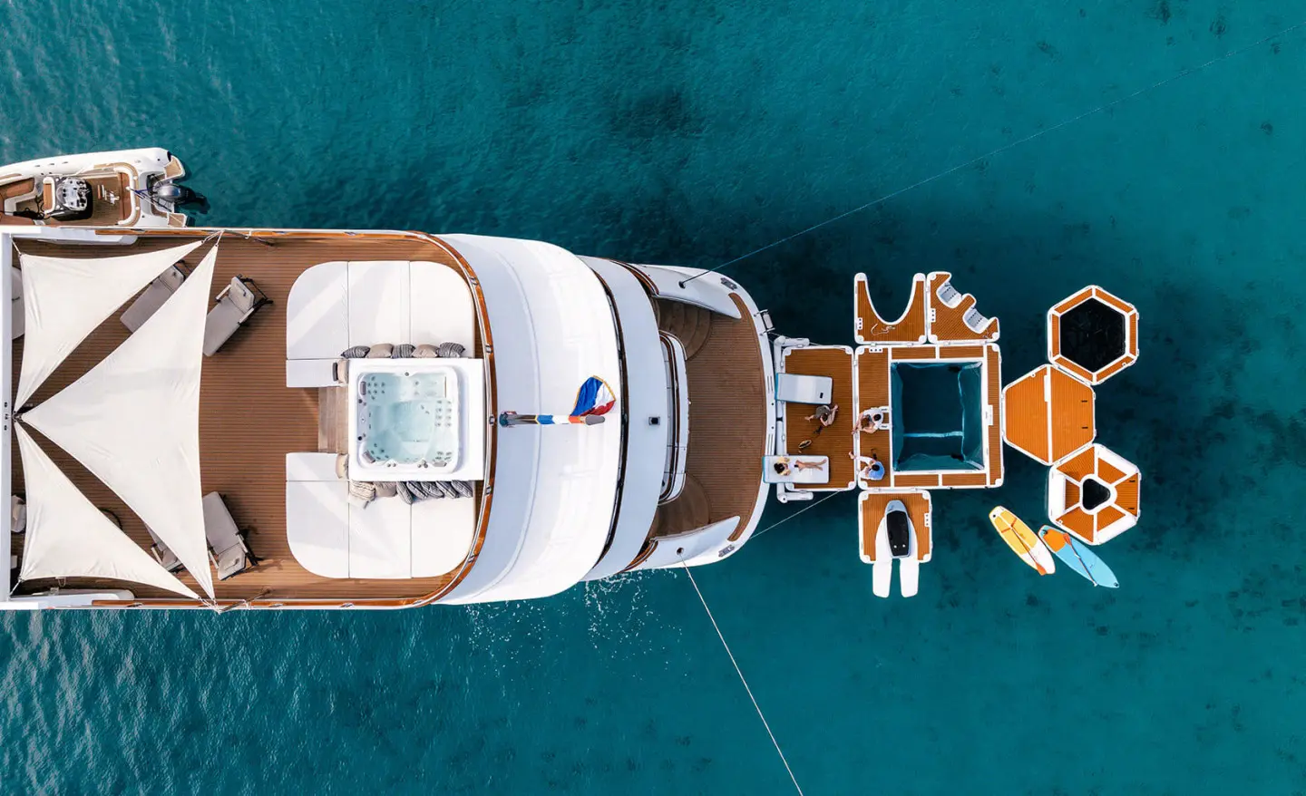 Top-down view of Cristal yacht at anchor in clear blue water at sunset