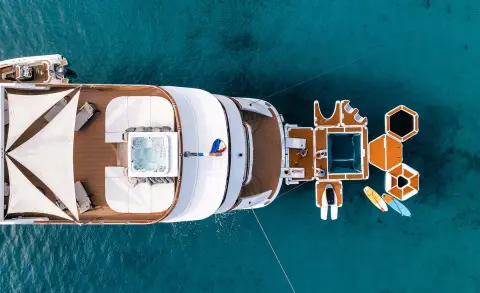 Top-down view of Cristal yacht at anchor in clear blue water at sunset