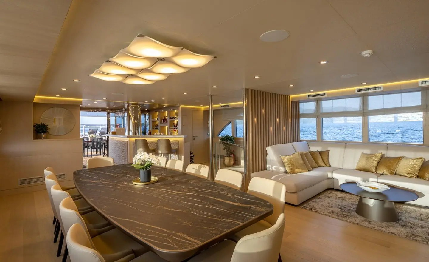 Luxurious yacht interior with dining table, seating, and warm ambient lighting