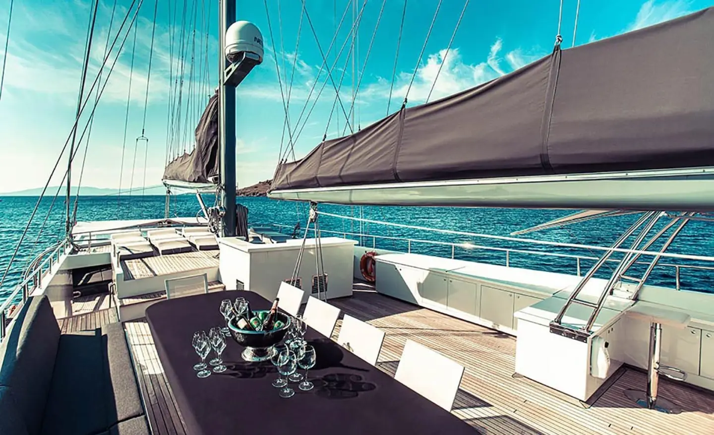 Virtuoso yacht deck at sunset with shaded seating area and blue sea