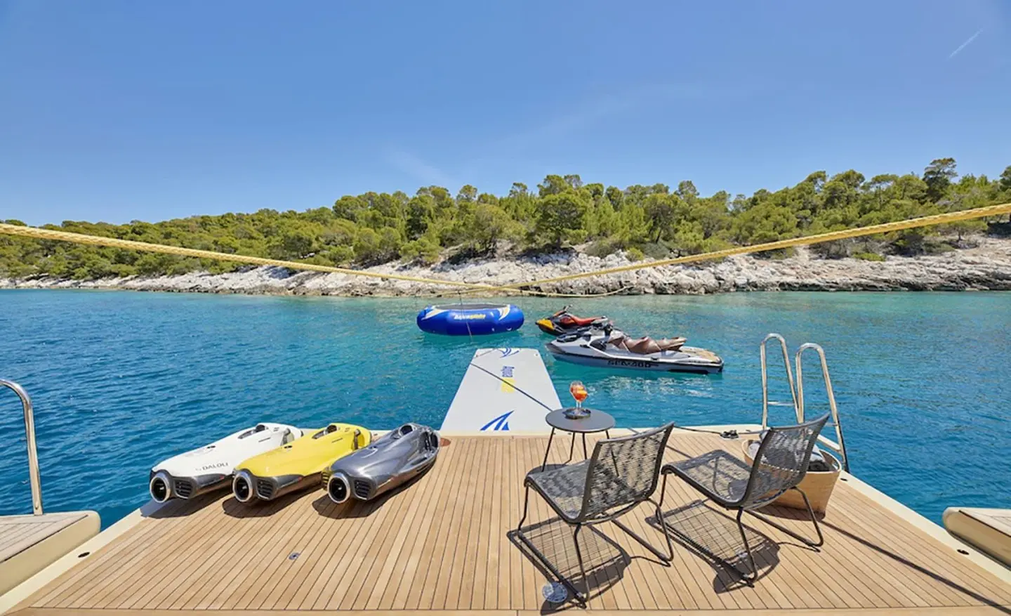 Daloli yacht dockside deck with lounge chairs and a bright blue sea