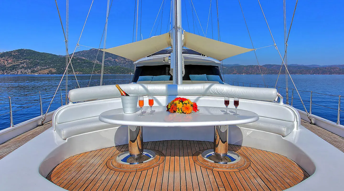 Angelo II gulet bow deck seating area with cushions and polished wood