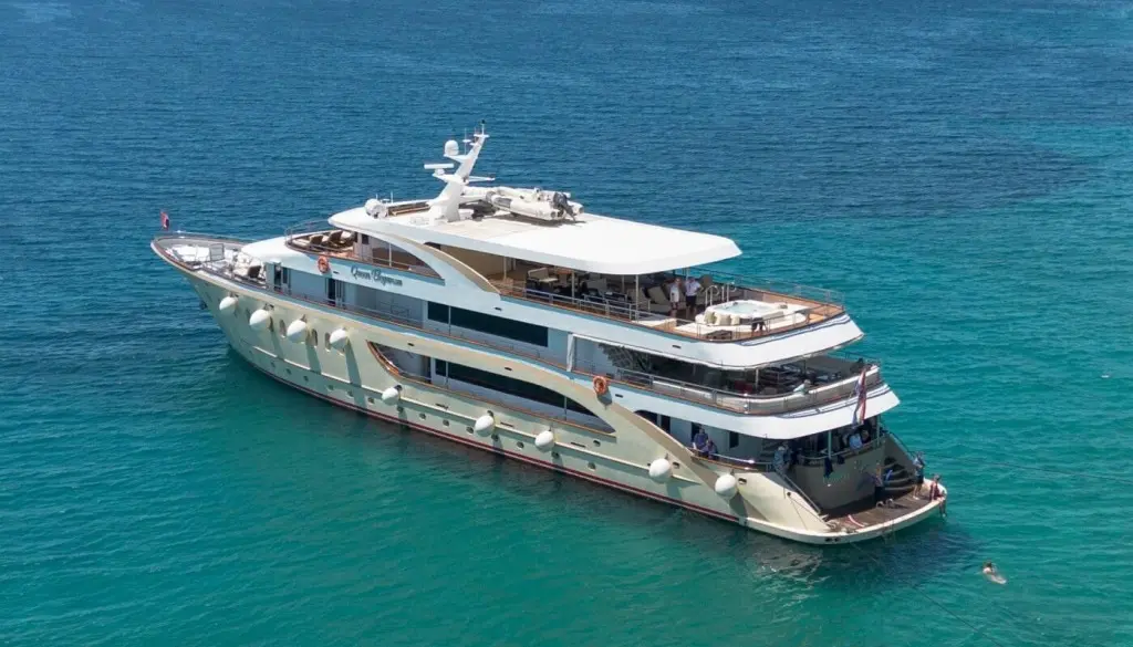 Luxurious Queen Eleganza yacht anchored in turquoise water, multiple decks visible