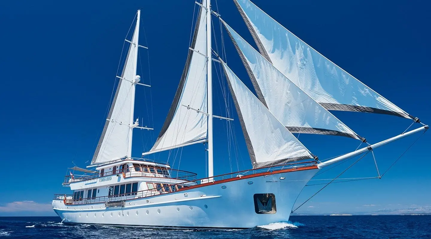 Luxurious sail yacht Corsario on the sea with large white sails and deep blue sky