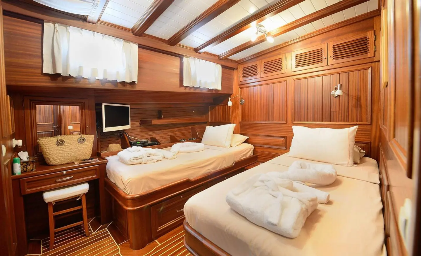 Interior of Zephyria II yacht cabin with two single beds and wooden paneling