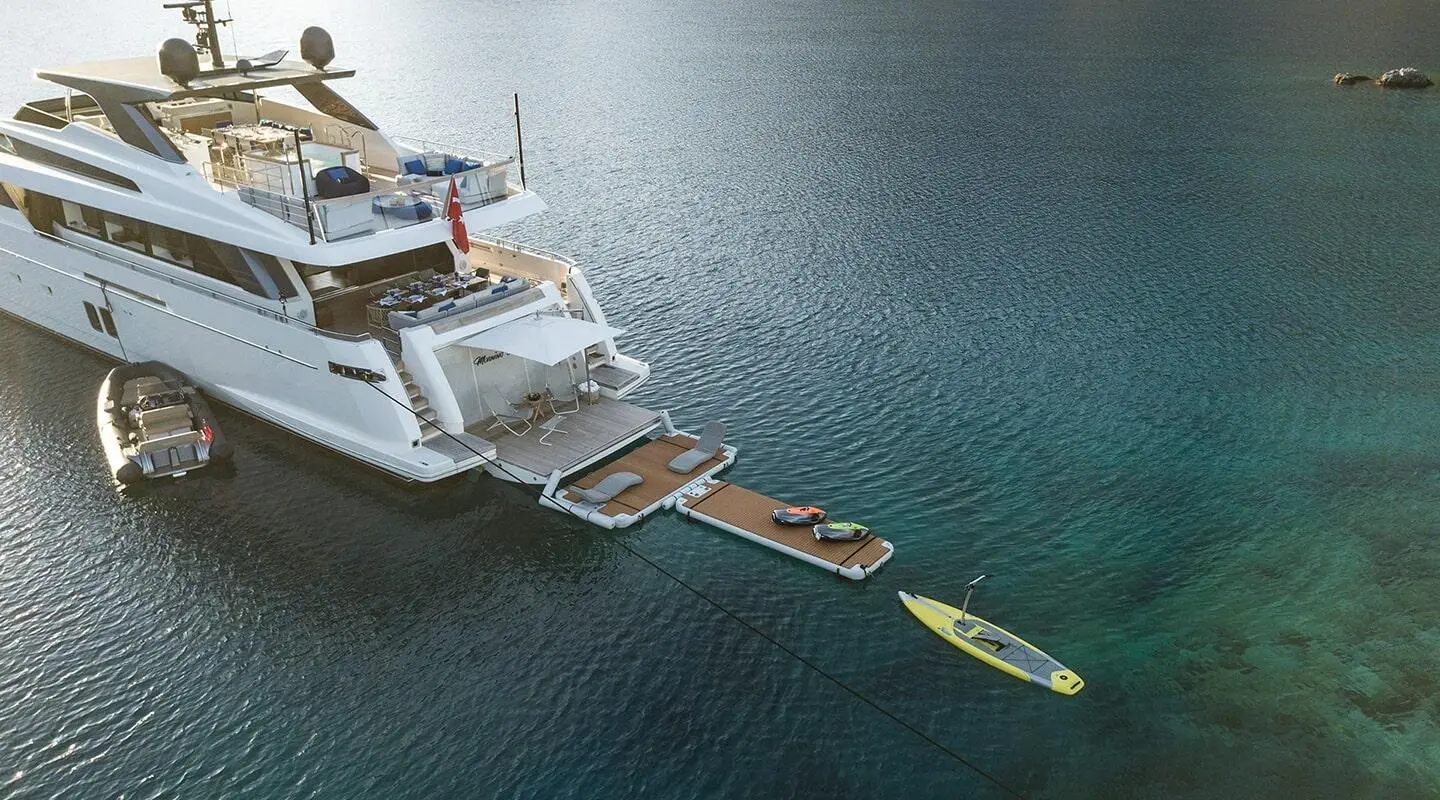 Morning Star yacht anchored by a floating platform with kayaks nearby