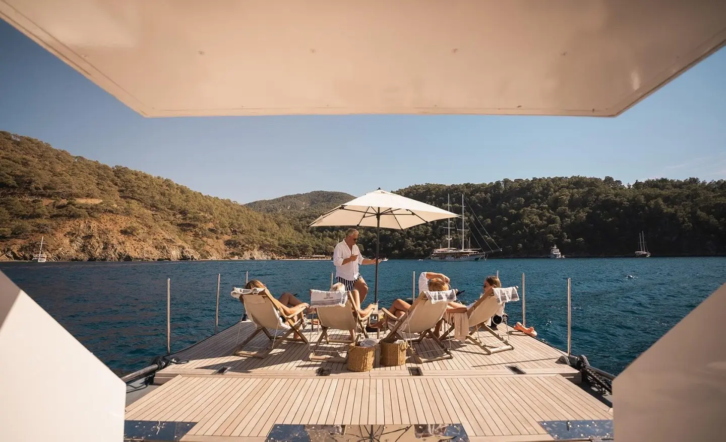 North Wind yacht deck lounge with sunbathers and umbrella by the pool