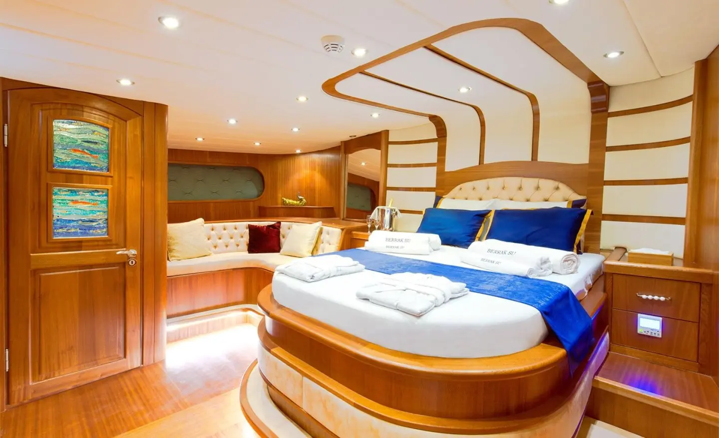 Luxurious gulet interior with wooden panels, upholstered bed and cushions