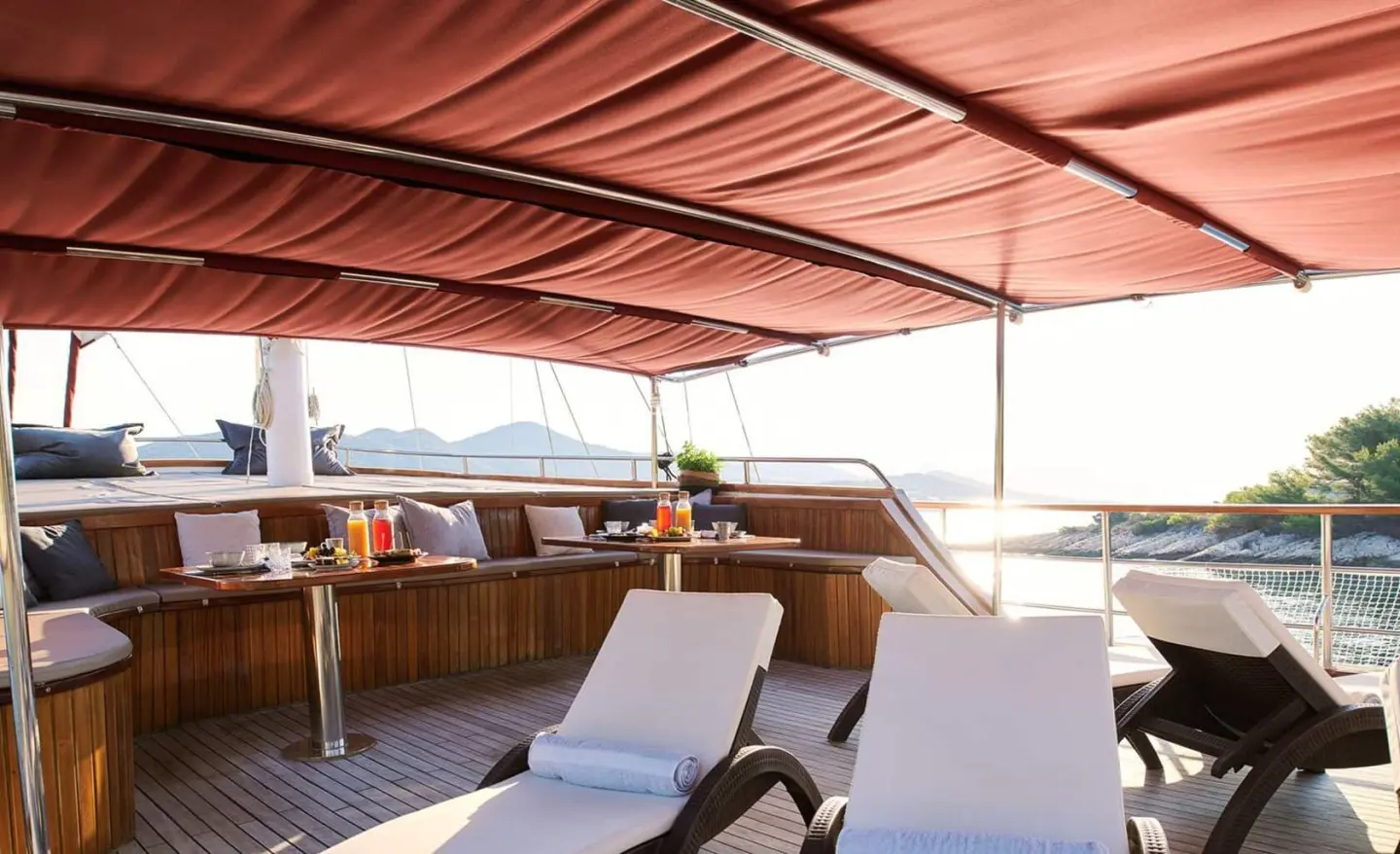 Cataleya luxury yacht interior deck seating under orange shaded canopy at sunset