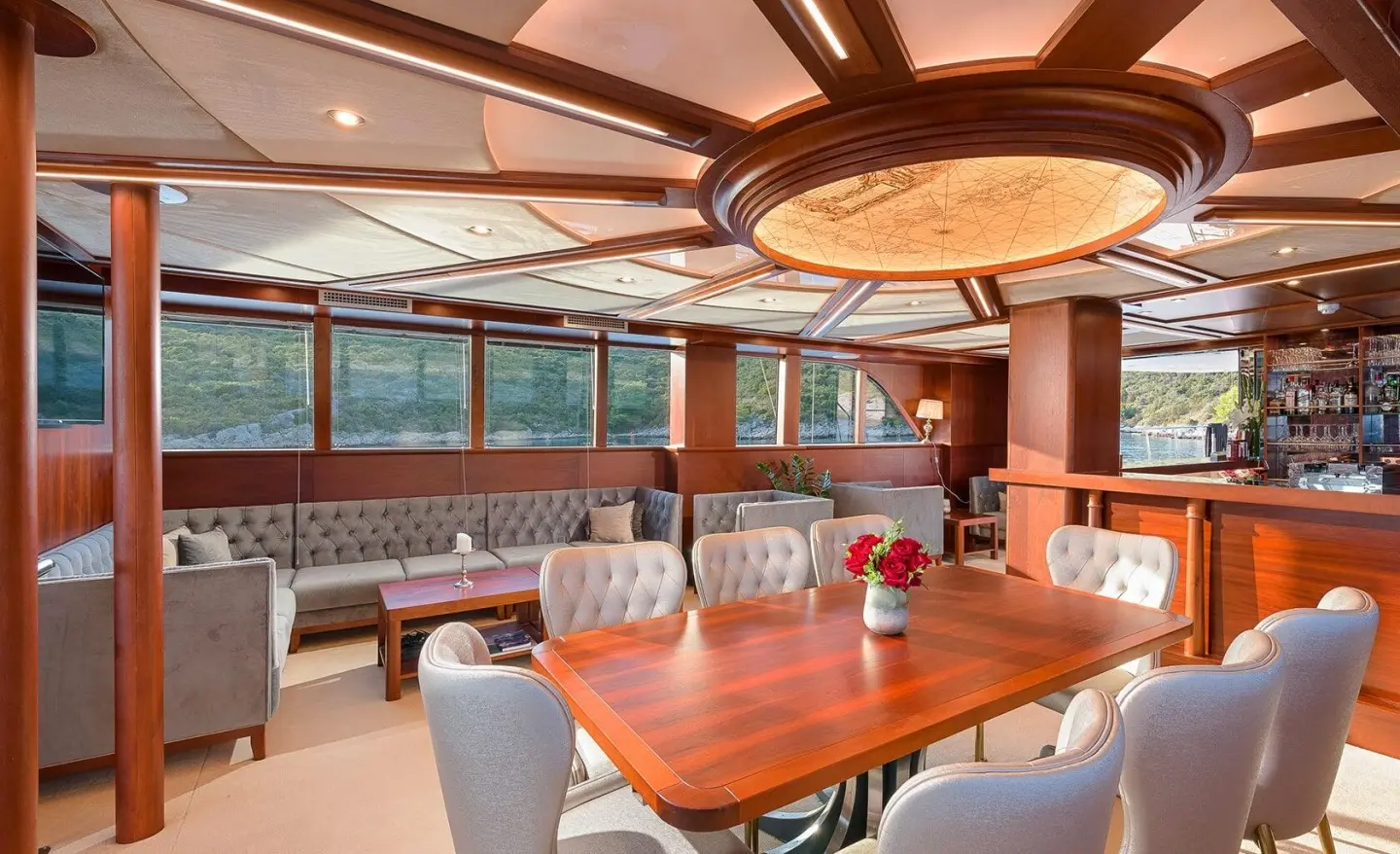 Luxurious yacht salon and dining area with a wooden table and seating