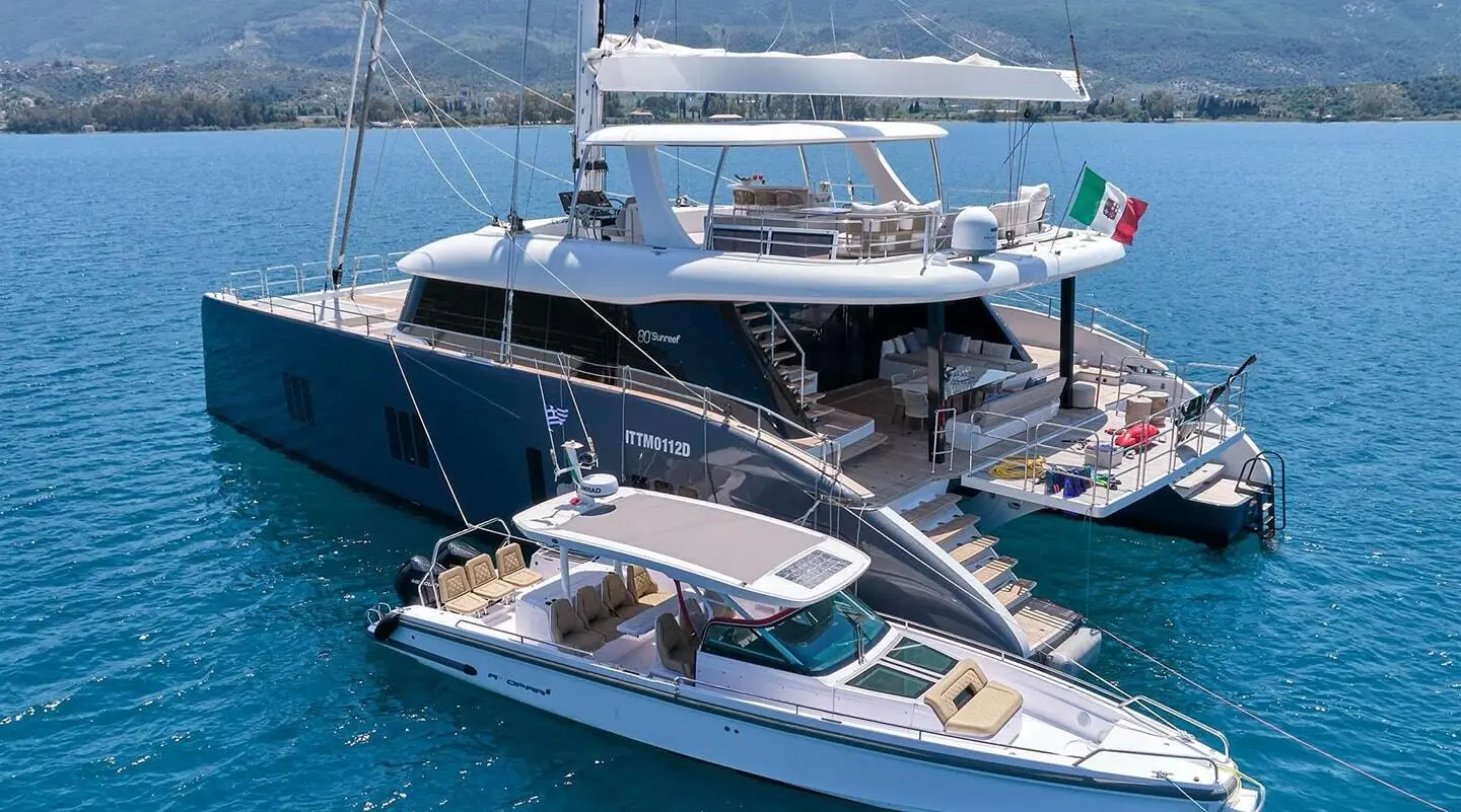 Genny luxury yacht with multiple decks docked in calm blue sea at sunset