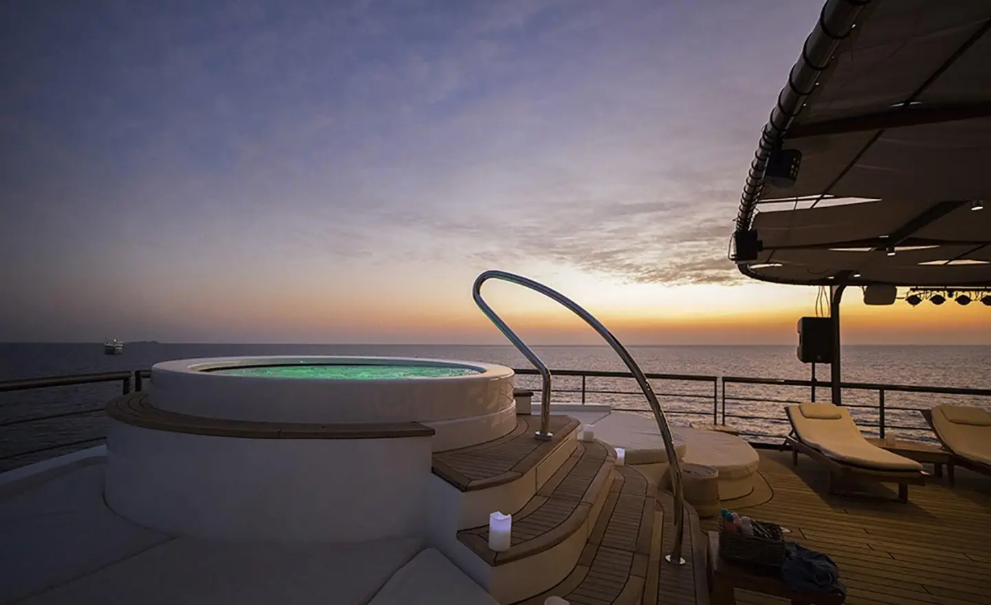 Chakra yacht deck at sunset with steps leading into calm sea and warm sky