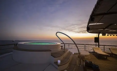 Chakra yacht deck at sunset with steps leading into calm sea and warm sky