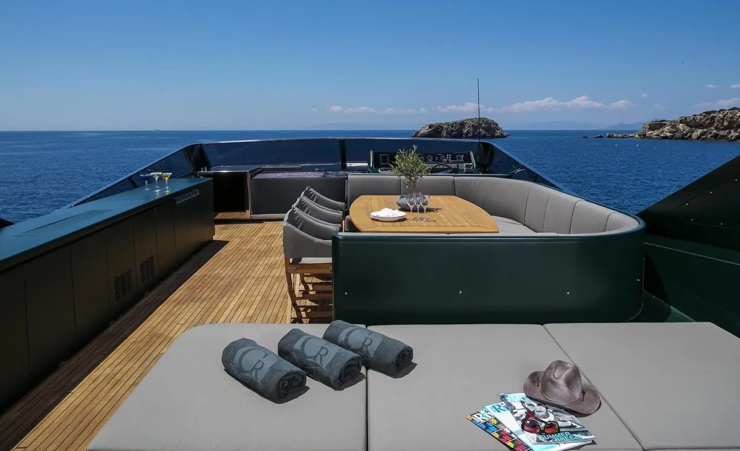 Deck of a luxury yacht with sun loungers, seating area, and ocean view