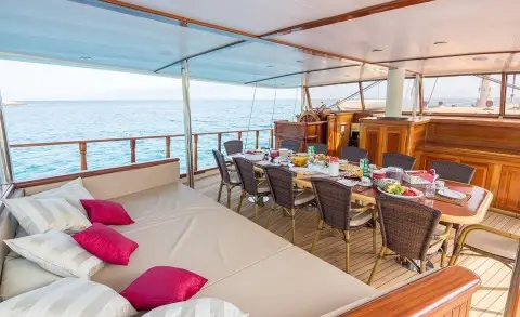 Morning Star aft deck on a gulet, seating area with table and cushions, sunlit sea view