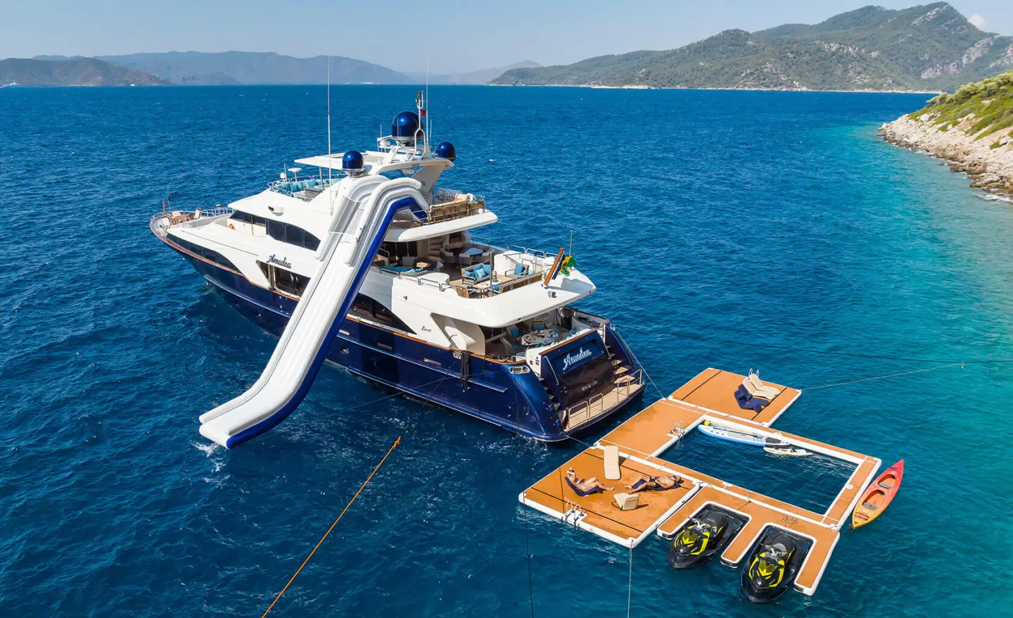 Amadea yacht moored with a water slide on deck in open sea