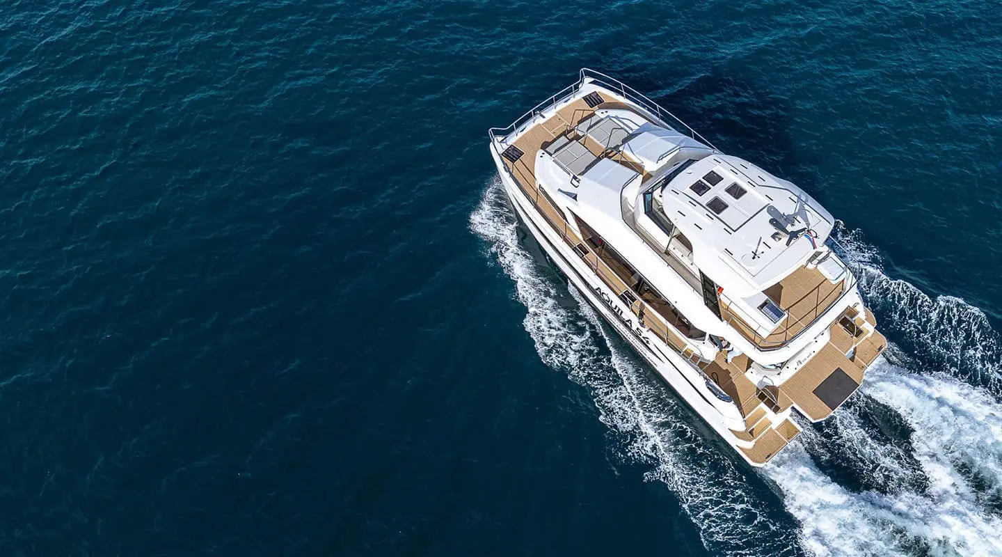 Overhead view of a luxury yacht sailing blue sea, white hull slicing water