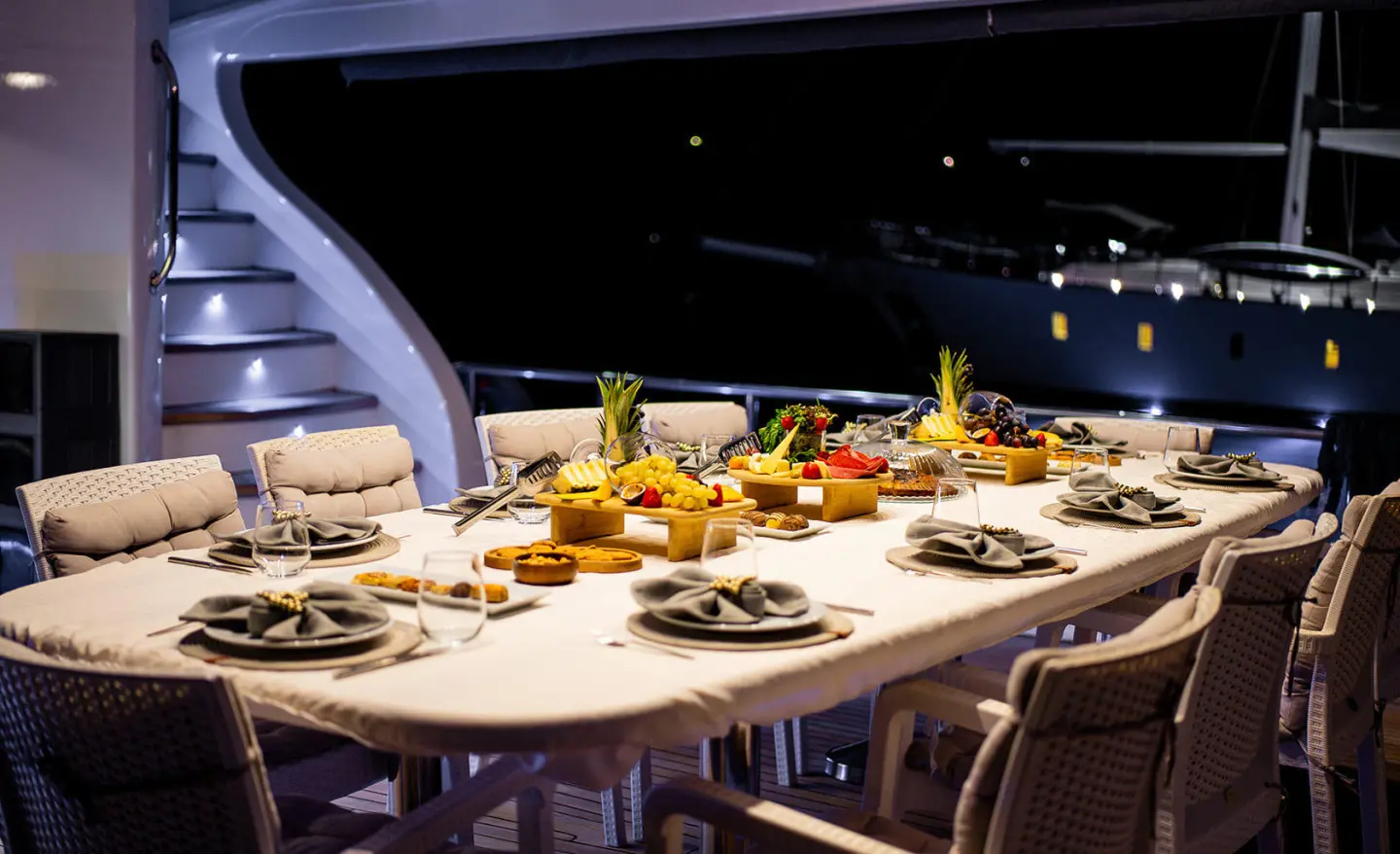 Gulet Queen Of Makri yacht table set with plates and fruit indoors