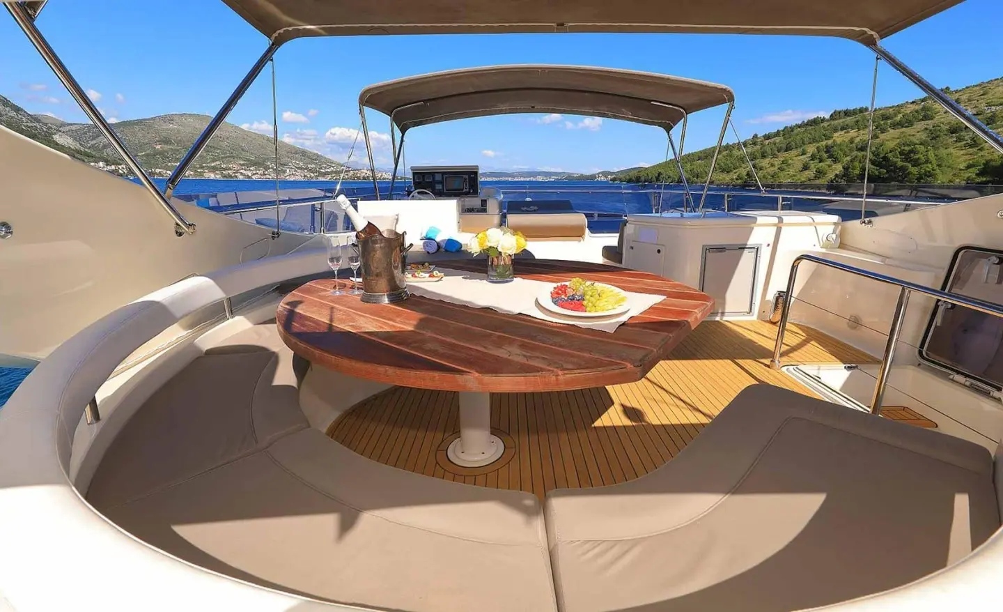 Quo Vadis I motoryacht flybridge: round wooden table and seating on deck