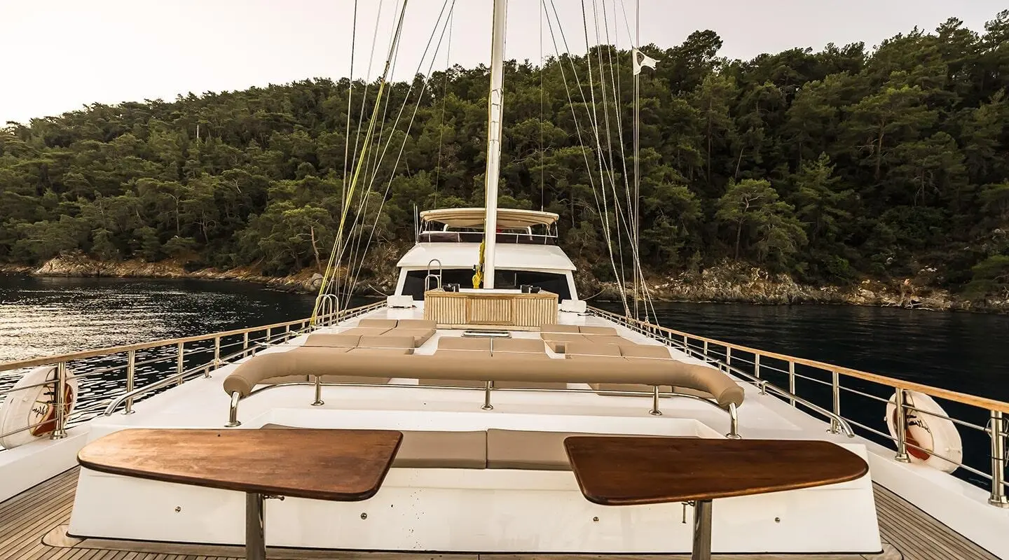 Belgin Sultan yacht deck view with manned helm and masts at sunset