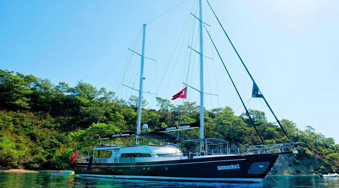 Maske 2 yacht docked with sails and Turkish flag near calm water