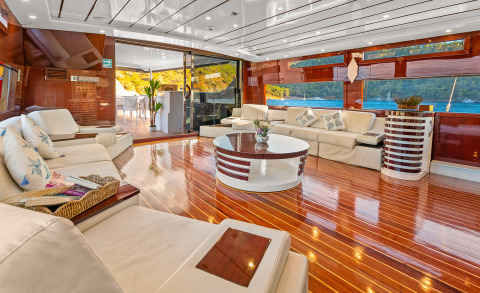 Esma Sultan yacht interior: luxurious salon with glossy wood flooring and cream sofas