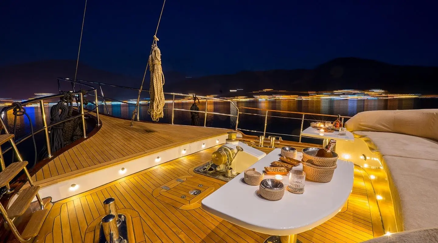 Yacht Happy Days deck at sunset with loungers and railings lit warmly