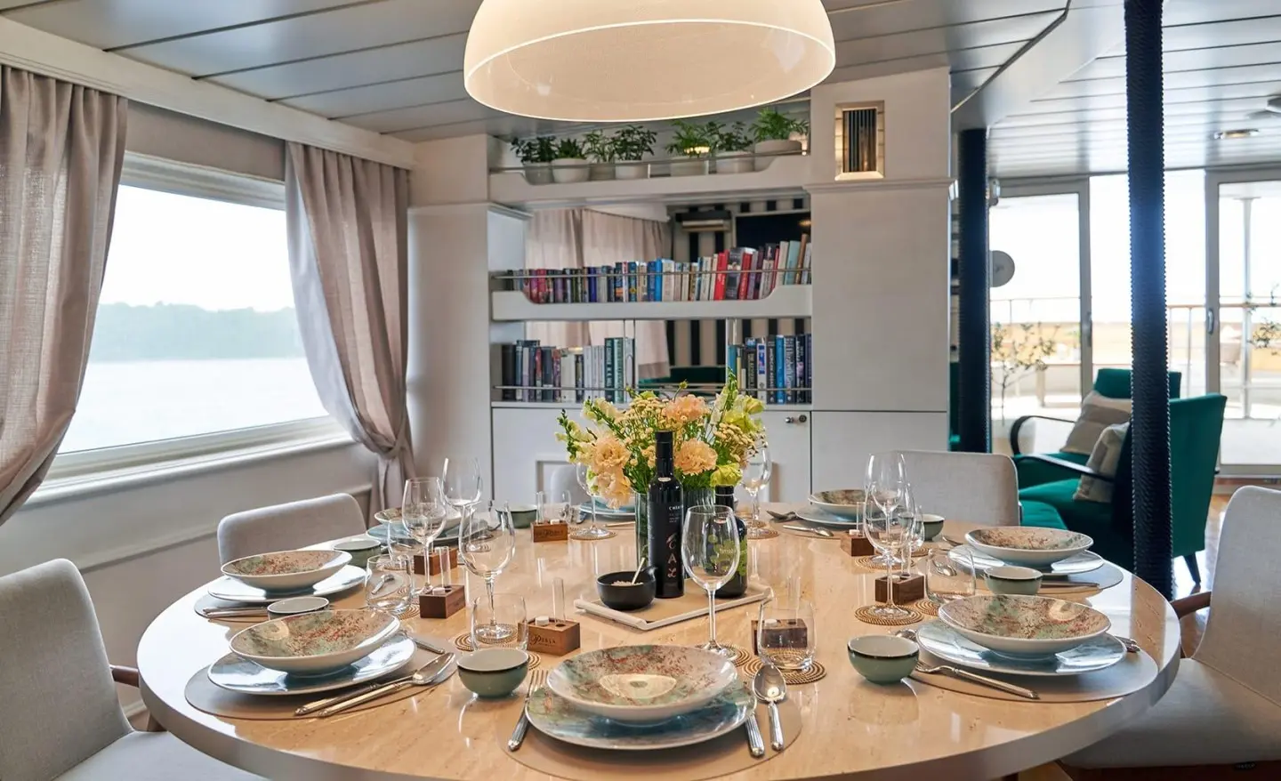 La Perla yacht dining area with round table set for a meal indoors