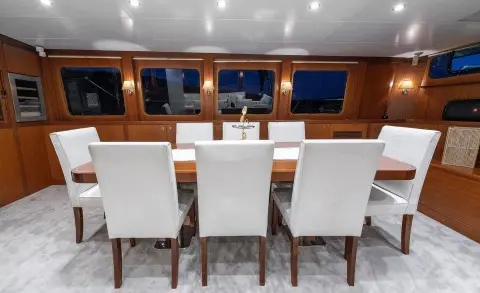 Luxurious yacht helm with white chairs and wooden dashboard at sunset