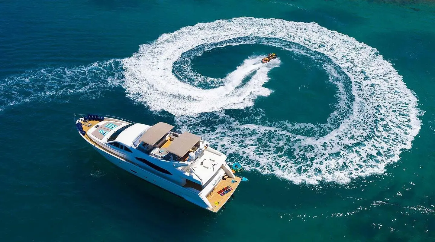 A motor yacht Quo Vadis I cruising blue water with wake swirl behind