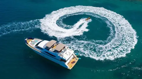 A motor yacht Quo Vadis I cruising blue water with wake swirl behind