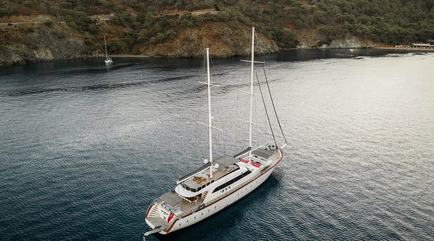 Gulet Queen Of Makri yacht anchored in calm water by a quay