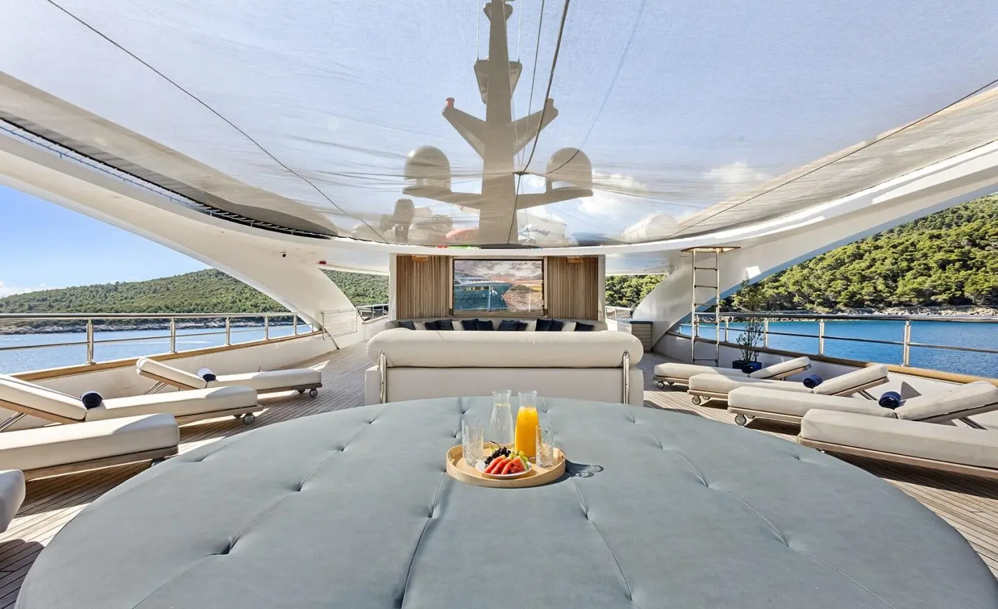 Luxurious yacht Bella deck with sun loungers and shaded seating area