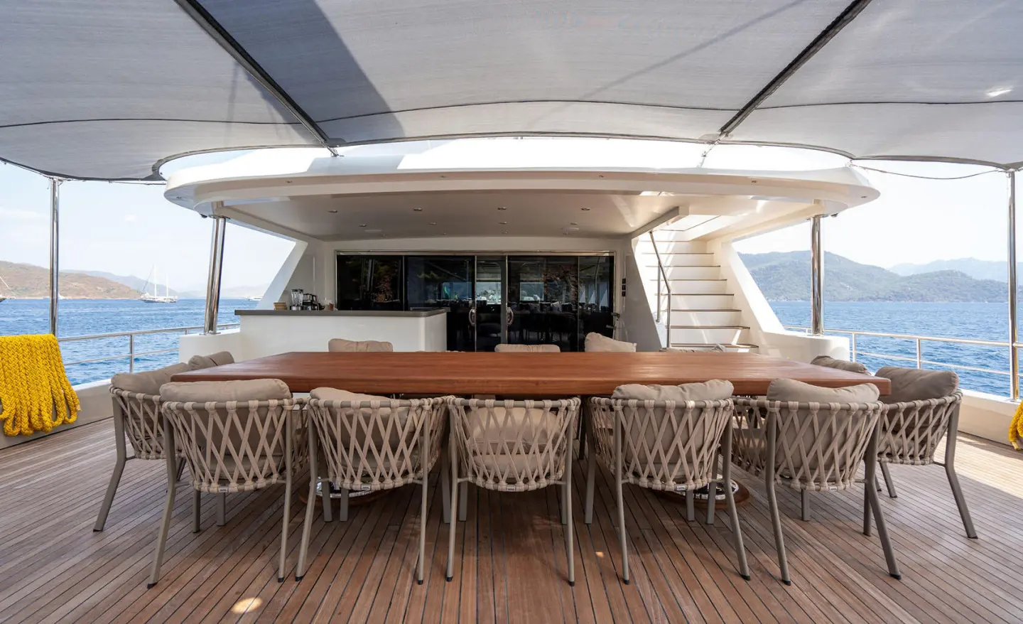 De Love yacht dining area on deck with wooden bar and stools
