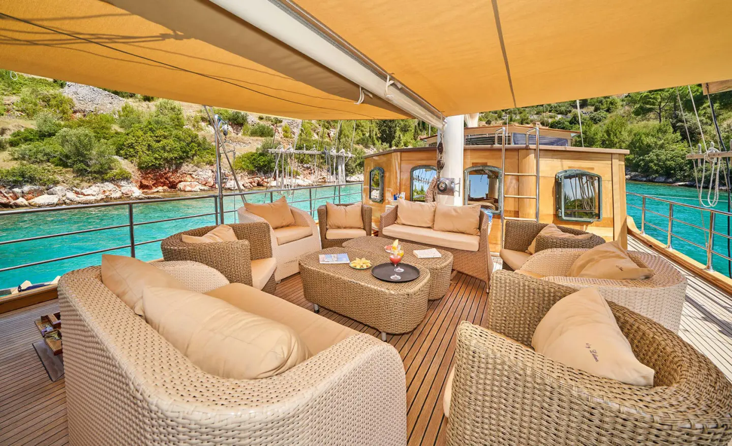 Luxurious yacht Libra with sunbeds and shaded seating on deck at sunset