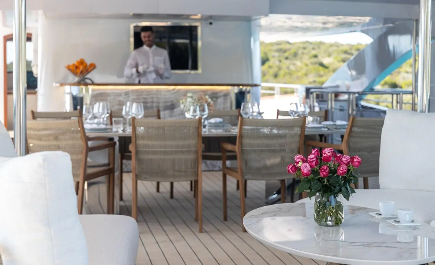 Olimp yacht deck with outdoor dining area, wooden floor, seating and flowers