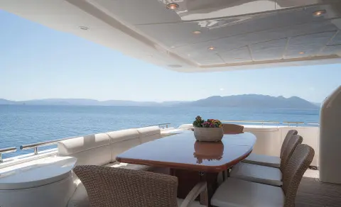 Lidia yacht dining area on deck overlooking calm sea at sunset