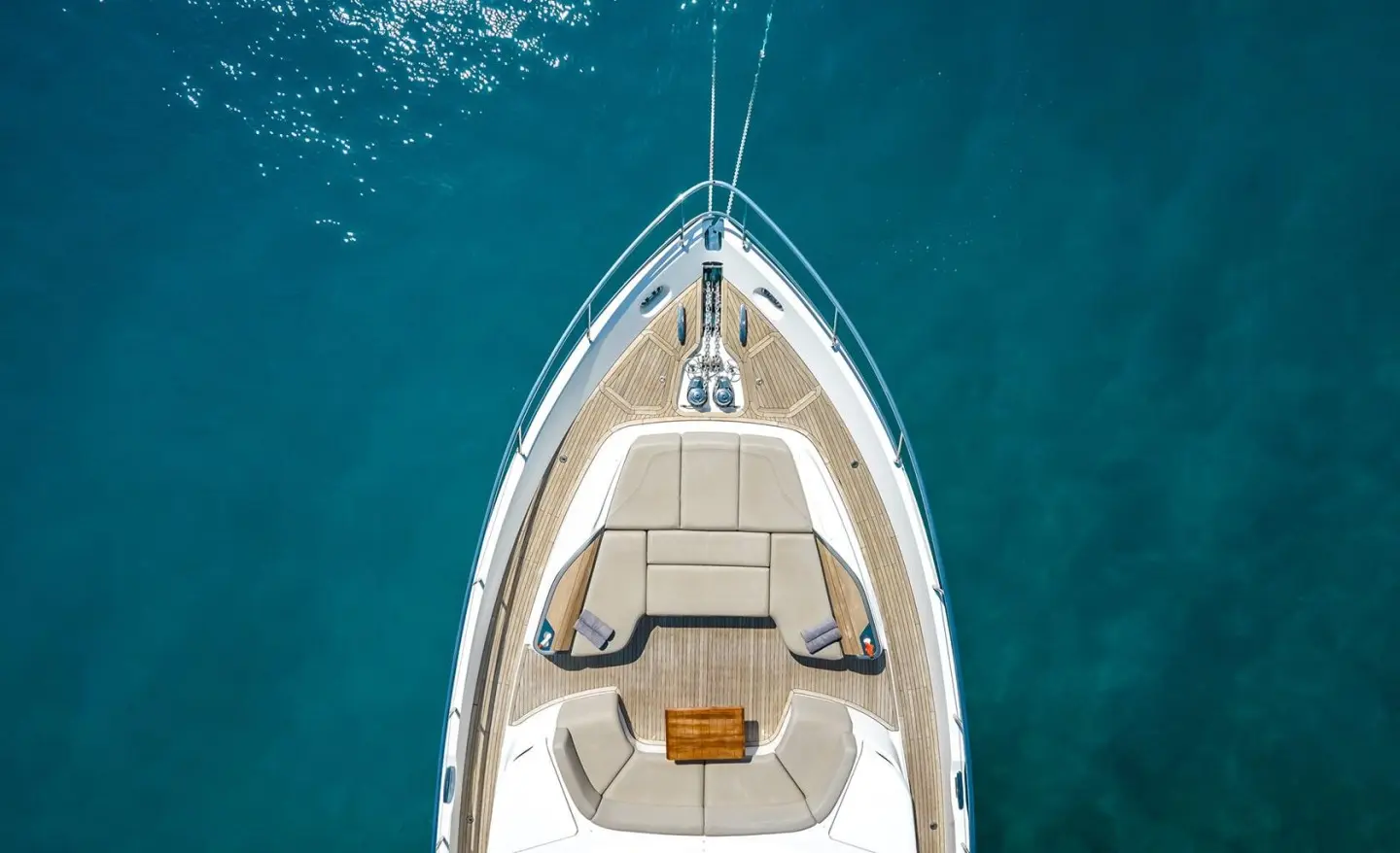 Top-down view of a small motor yacht Vista at anchor in blue water