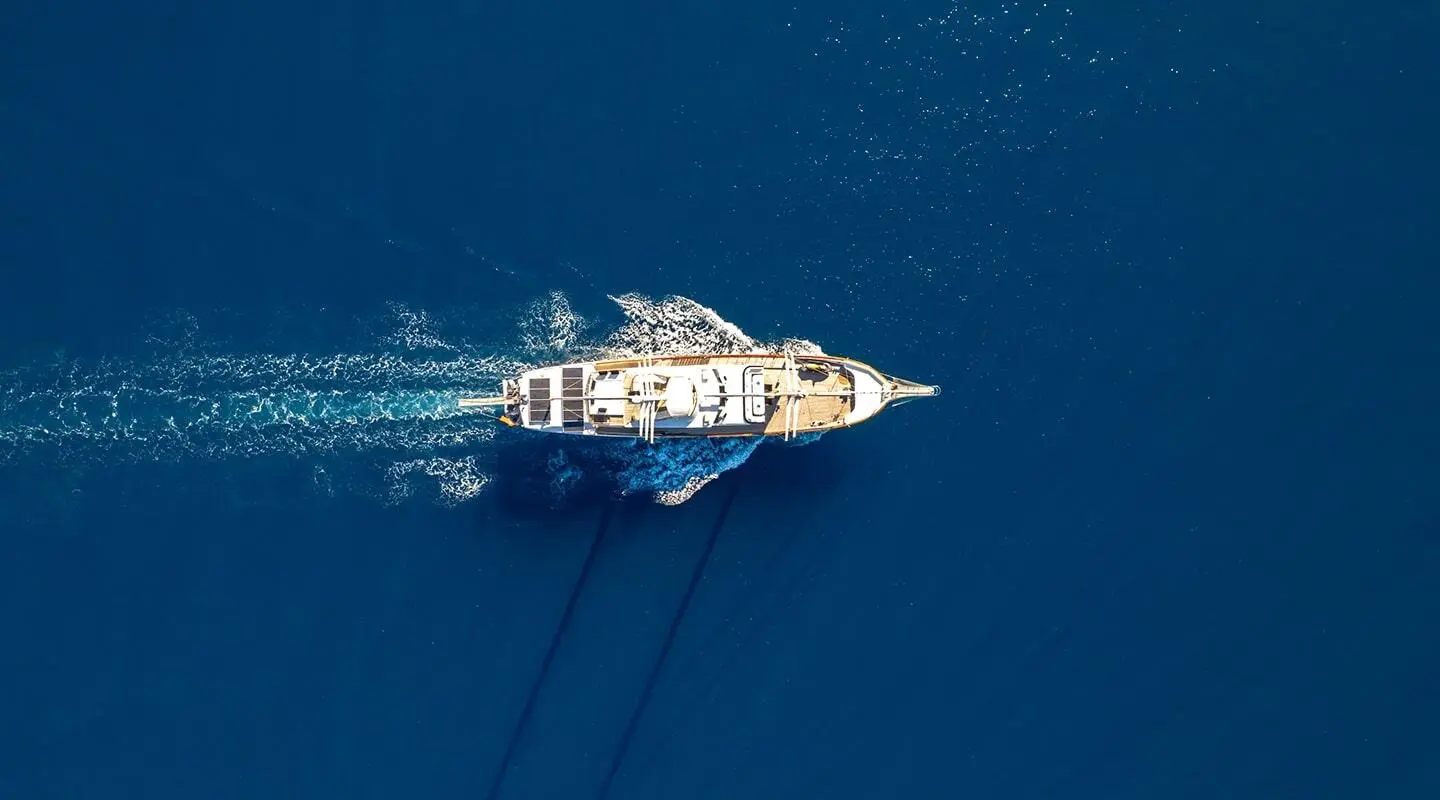 Top-down view of a sleek white yacht named Double Eagle at sea during daylight