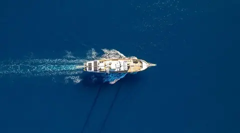 Top-down view of a sleek white yacht named Double Eagle at sea during daylight