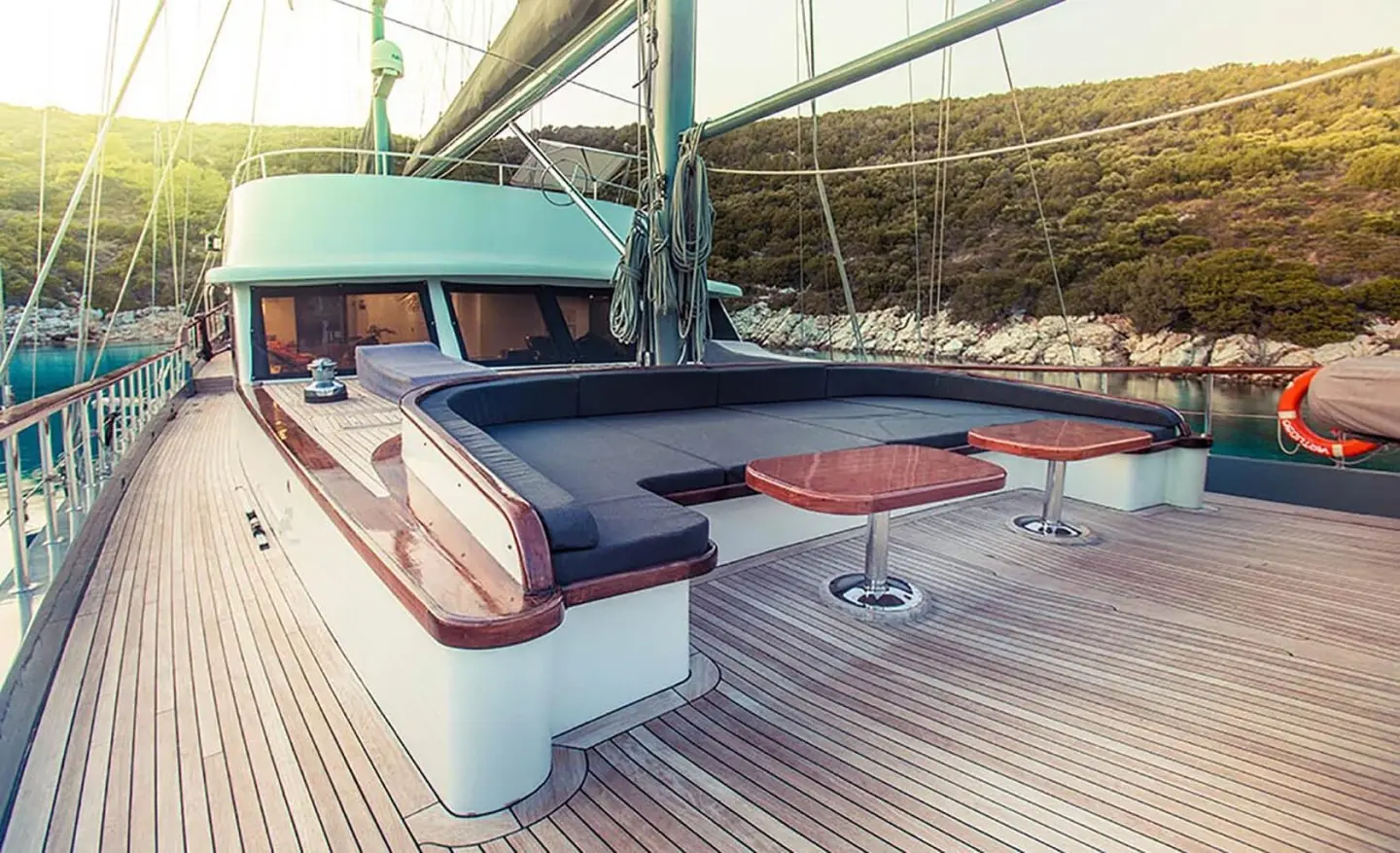 Luxurious yacht Virtuoso docked at sunset with white and blue seating area
