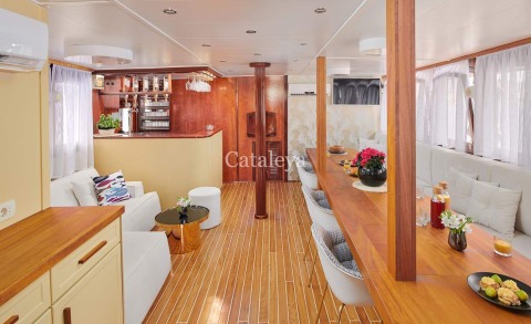 Luxurious interior with wooden pillars, bar area and long wooden dining table