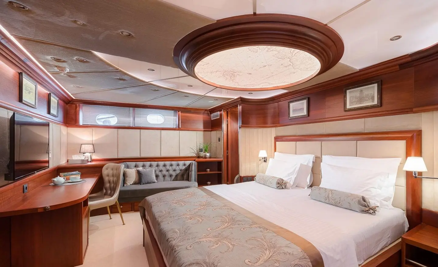 Luxurious yacht Lady Gita bedroom with polished wood cabinetry and designer bed