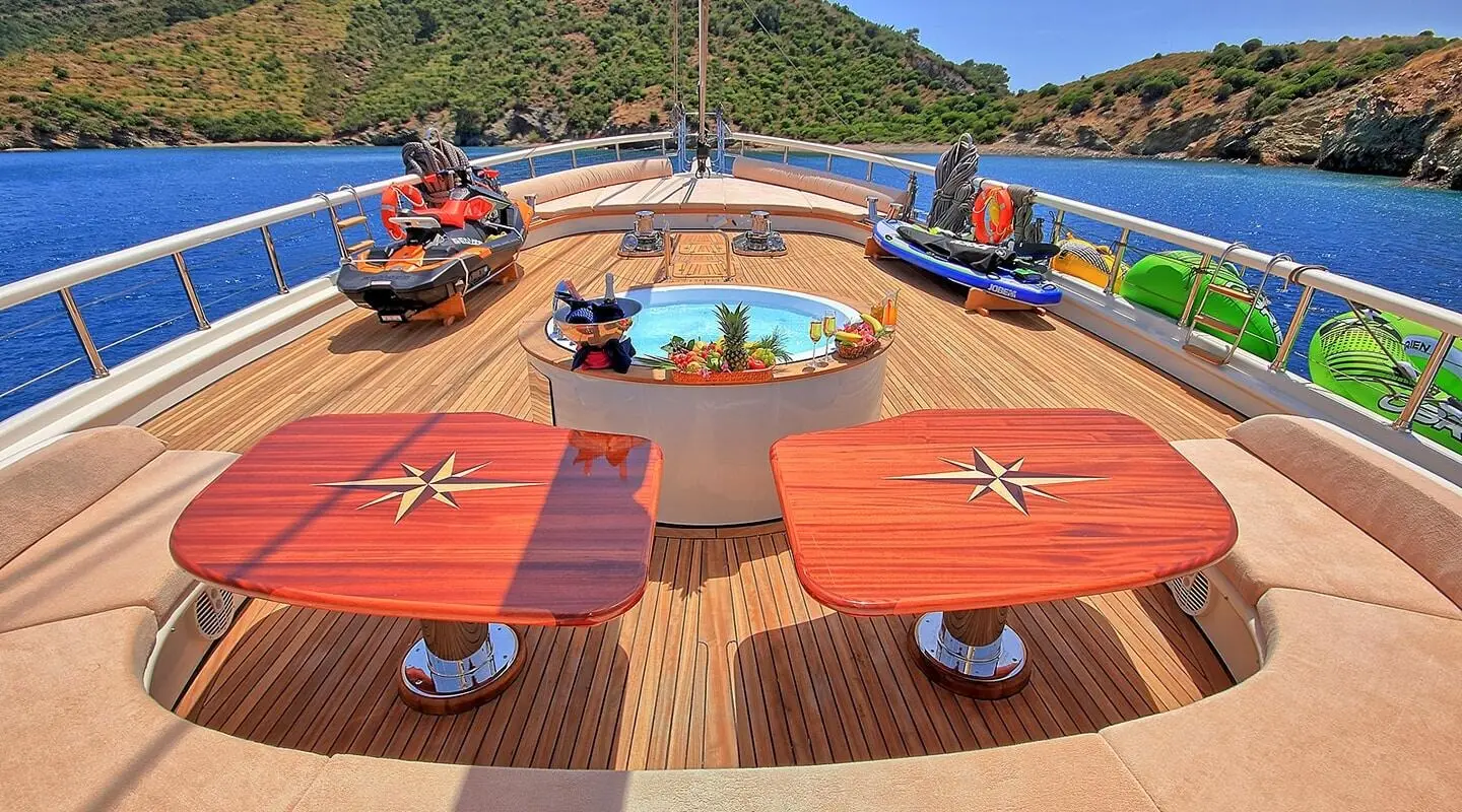 Bow deck of Queen Of Salmakis gulet with red sun loungers and blue cushions