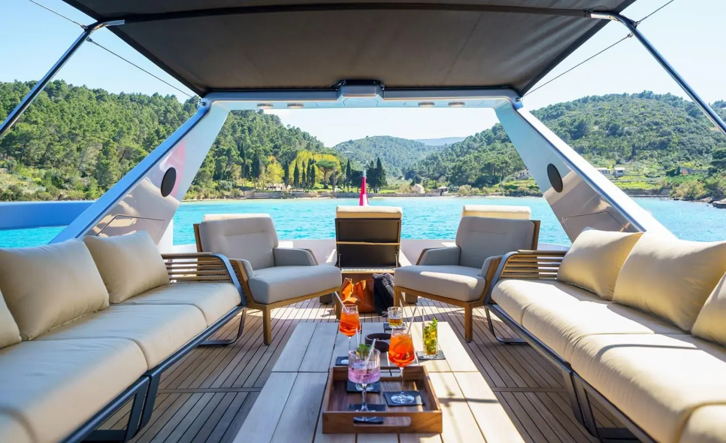 Phantom yacht aft deck scene with seating, table, and view of sea and coastline