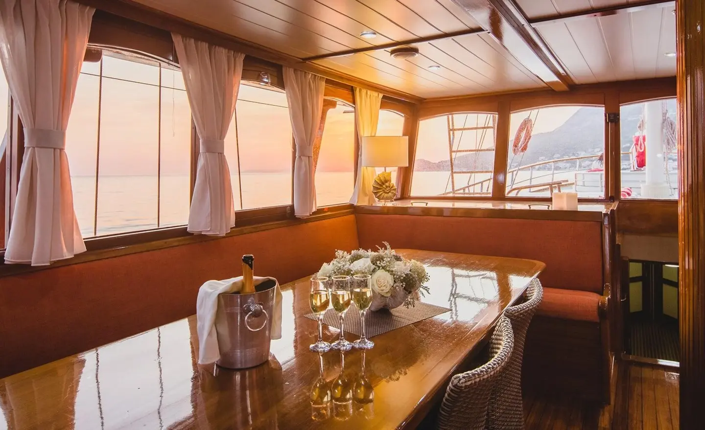 Luxurious interior of Altair yacht with wooden table and warm lighting